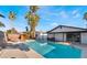 A backyard oasis with a sparkling pool, hot tub, palm trees, and covered patio at 3625 Winner Dr, Las Vegas, NV 89120