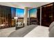 Bedroom featuring floor-to-ceiling windows offering skyline views and decoratively pillowed chair at 3722 Las Vegas Blvd # 3209, Las Vegas, NV 89158