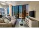 Elegant living room with floor-to-ceiling windows, a comfortable sofa, and city views at dusk at 3722 Las Vegas Blvd # 3209, Las Vegas, NV 89158