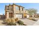 Two-story home showcasing a paved driveway, desert landscaping, stone accents and neutral paint at 3770 S Rosy Carina Pl, Henderson, NV 89052