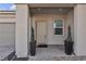 Inviting covered front porch of a home featuring manicured greenery in planters at 4267 E Highvale Ct, Pahrump, NV 89061