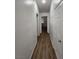 Hallway with wood-look flooring and white walls leads to rooms at 4610 Cannon Beach St, Las Vegas, NV 89122