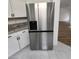 Stainless steel refrigerator next to granite countertops and white cabinets at 4610 Cannon Beach St, Las Vegas, NV 89122