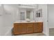 Double vanity bathroom with a large mirror and wood cabinets at 4793 Cannon Hill Ct, Las Vegas, NV 89130