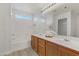 Double vanity bathroom with soaking tub and light wood cabinets at 4793 Cannon Hill Ct, Las Vegas, NV 89130