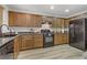 Modern kitchen with wood cabinets and black appliances at 4793 Cannon Hill Ct, Las Vegas, NV 89130