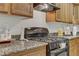 Gas range, granite countertops, and wood cabinets at 4793 Cannon Hill Ct, Las Vegas, NV 89130