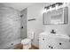 Modern bathroom with marble shower, white vanity, and wood-look tile at 6520 Evergreen Ave, Las Vegas, NV 89107