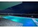 Brightly lit pool and spa area with distant city lights at 658 Dragon Peak Dr, Henderson, NV 89012