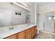 Bathroom with double sinks, a shower, and wood cabinets at 700 Carnegie St # 4812, Henderson, NV 89052