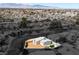 An aerial view shows the single-story home with desert landscaping nestled in a neighborhood near the mountains at 704 Berry Cir, Las Vegas, NV 89107