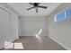 Bedroom featuring light wood floors, neutral walls, ceiling fan, closet, and a window for natural light at 704 Berry Cir, Las Vegas, NV 89107