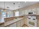 Spacious kitchen featuring white cabinets, tile countertops, and modern appliances at 752 Golden Sedum Dr, Henderson, NV 89011