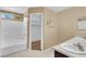 Bathroom featuring a tub-shower combo, dual sinks, and tan walls at 7912 Rushmore Ave, Las Vegas, NV 89131