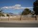 Single-story home with a white picket fence, desert landscaping, and mountain views, creating a charming and inviting curb appeal at 7912 Rushmore Ave, Las Vegas, NV 89131