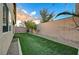 Low-maintenance backyard with artificial turf, desert landscaping, and neutral privacy wall at 7992 Barntucket Ave, Las Vegas, NV 89147