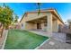 Charming backyard with covered patio, ceiling fans, and low-maintenance artificial turf offers outdoor enjoyment at 7992 Barntucket Ave, Las Vegas, NV 89147