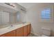 Bathroom with double vanity, tiled floors, large mirror, and a window with shutters at 7992 Barntucket Ave, Las Vegas, NV 89147