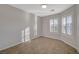 An empty bedroom featuring tile floors, neutral walls and light from the two windows at 7992 Barntucket Ave, Las Vegas, NV 89147