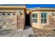 Exterior view of home featuring stone accents, tan paint and a two-car garage at 7992 Barntucket Ave, Las Vegas, NV 89147