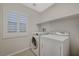 This laundry room features tile floors, shelving and a front-loading washer and dryer at 7992 Barntucket Ave, Las Vegas, NV 89147