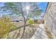 Side yard featuring a walkway, desert landscaping, and mature trees providing ample shade at 8201 Lake Isle Ct, Las Vegas, NV 89145