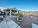 Expansive backyard featuring a covered patio, mature trees, and low-maintenance gravel landscaping at 8203 Heather Rock Ct, Las Vegas, NV 89117