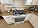 Close-up of a stainless steel gas range and oven with speckled granite countertops at 8203 Heather Rock Ct, Las Vegas, NV 89117