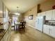 Open kitchen with dining area and living room beyond, white cabinets, tiled floors at 8203 Heather Rock Ct, Las Vegas, NV 89117