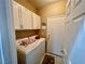 Convenient laundry room with white cabinets, washer, dryer, and access door at 8203 Heather Rock Ct, Las Vegas, NV 89117