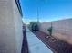 Narrow side yard featuring a walkway, gravel landscaping, and mature trees, offering privacy at 8203 Heather Rock Ct, Las Vegas, NV 89117