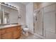 Bathroom with a glass-enclosed shower, vanity, sink, toilet and light tile floors at 85 Alerion St, Las Vegas, NV 89138