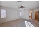 Spacious carpeted bedroom with a ceiling fan and view of the bathroom at 85 Alerion St, Las Vegas, NV 89138