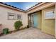 Inviting courtyard with lush greenery and charming blue door, creating a warm entrance at 85 Alerion St, Las Vegas, NV 89138