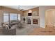 Staged living room with fireplace, modern furniture, neutral colors, and large windows allowing ample light at 85 Alerion St, Las Vegas, NV 89138