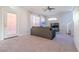 Spacious living room with a ceiling fan, leading to a back door and staircase at 8523 Peaceful Dreams St, Las Vegas, NV 89139