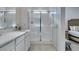 Well-lit bathroom featuring a sleek vanity, modern shower with glass door, and partial bedroom view at 889 Elmwood Forest Ln, Las Vegas, NV 89138