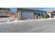 Home exterior with a white garage door, minimal landscaping, and an exterior rock wall feature at 889 Elmwood Forest Ln, Las Vegas, NV 89138