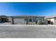 Gray single-story home with a white garage door, landscaped front yard, and a clear blue sky at 889 Elmwood Forest Ln, Las Vegas, NV 89138