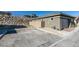 View of the home's exterior with a concrete driveway, rock wall, and minimalist front yard landscaping at 889 Elmwood Forest Ln, Las Vegas, NV 89138