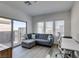 Stylish living room with a gray sofa, modern desk, and sliding glass door to the backyard at 889 Elmwood Forest Ln, Las Vegas, NV 89138