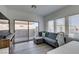 Stylish living room with a gray sofa, modern desk, and sliding glass door to the backyard at 889 Elmwood Forest Ln, Las Vegas, NV 89138