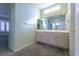 Bathroom features a double vanity, a large mirror, decorative lighting, and views of the bedroom at 9524 Quail Ridge Dr, Las Vegas, NV 89134