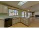 Bright kitchen featuring wood floors, a skylight, an island, and a window with views of the backyard at 9524 Quail Ridge Dr, Las Vegas, NV 89134