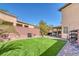 Landscaped backyard with artificial turf and covered patio at 10212 Cider Mill Rd, Las Vegas, NV 89135