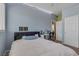 Light blue bedroom with a queen bed, desk, and closet at 10212 Cider Mill Rd, Las Vegas, NV 89135