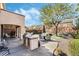 Outdoor kitchen and BBQ, with landscaped yard, trees, and patio seating at 1163 Highbury Grove St, Henderson, NV 89002