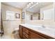 Neutral bathroom with a single sink vanity, tile backsplash, and decorative floral paintings at 1163 Highbury Grove St, Henderson, NV 89002