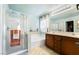 Bright bathroom featuring a glass-enclosed shower, soaking tub, and double vanity at 1163 Highbury Grove St, Henderson, NV 89002