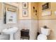 Elegant powder room featuring a pedestal sink, tiled walls, and decorative wall art at 1163 Highbury Grove St, Henderson, NV 89002